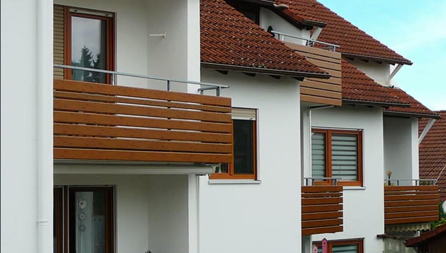 Fertig montierte Alu-Balkonverkleidung in Holzoptik an einem Wohnhaus